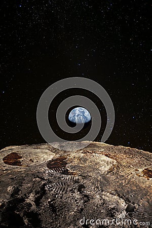 Footsteps on the moon surface, Earth rises above lunar horizon. Stock Photo