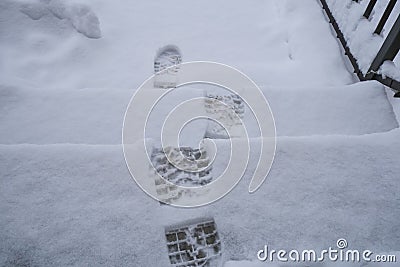 Footsteps in snow on staircase close-up top view. Winter season. natural background Stock Photo