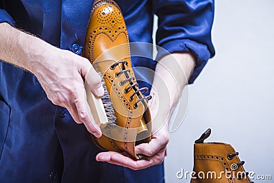 Footwear Ideas. Closeup of Mans Hands with Cleaning Brush Stock Photo