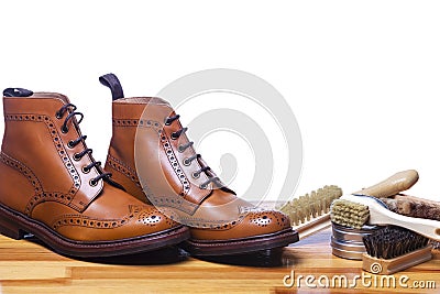 Footwear Ideas and Concepts. Closeup of Tanned Mens Derby Boots With Cleaning Brushes and Wax Stock Photo