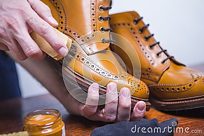 Footwear Ideas. Hands of Professional male Shoes Cleaner Stock Photo