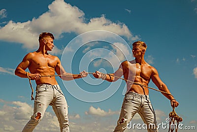 Force and power. Twins competitors with muscular bodies. Strong men pull rope with muscular hand strength. Men shows off Stock Photo