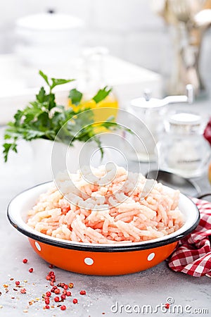 Forcemeat. Raw ground chicken meat in bowl on white kitchen table. Fresh minced chicken breast meat Stock Photo