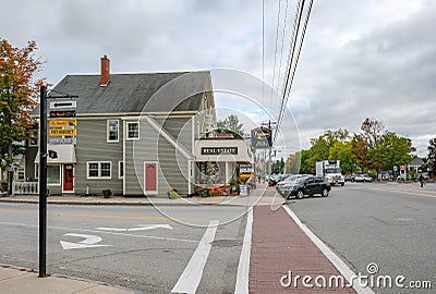 Exterior view of an empty side street junction showing a timber-built Real Estate building together with a parking lot at a road Editorial Stock Photo