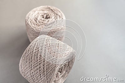 Foreground of two beige ball of wool on gray paper Stock Photo
