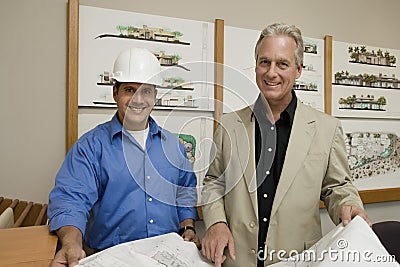 Foreman With Client Holding Blueprint Stock Photo