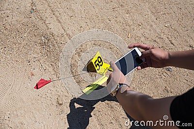 forensic hand use mobile phone take picture of evidence with evidence marker in crime scene training Stock Photo