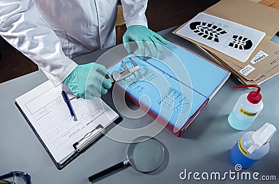 Forensic scientist investigates shoeprint mould evidence in crime lab Stock Photo