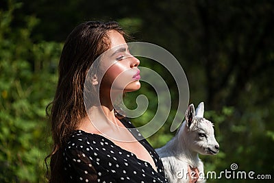 Forest nymph in a pine forest with lamb. Beautiful girl, Nymph. Adorable sensual young woman with lamb looks like Angel Stock Photo