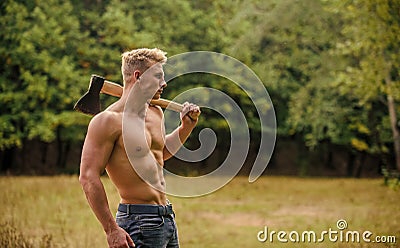 Forester with axe. Sexy macho bare torso. Surviving in wild nature. Muscular athlete in forest. Sport and fitness Stock Photo