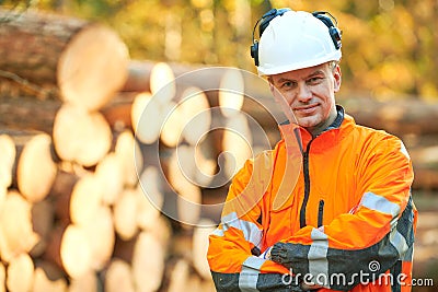 Forestry worker in protective workwear in front of wood lumber cut tree Stock Photo