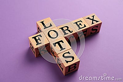 Forex lots. Wooden cubes placed as crossword on purple background, closeup Stock Photo