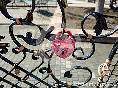 Forged bridge for lovers with wedding locks in the shape of a heart. Editorial Stock Photo
