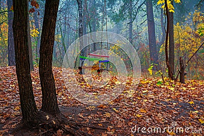 Forgotten children`s swing on the background of an autumn park Stock Photo