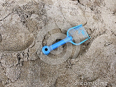 Forgotten children's toy shovel in the sand in the sandbox Stock Photo