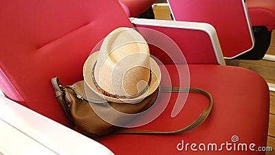 Forgotten handbag and a summer straw hat on the seat Stock Photo