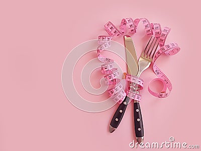 Fork knife measuring balance tape colored background overeating Stock Photo