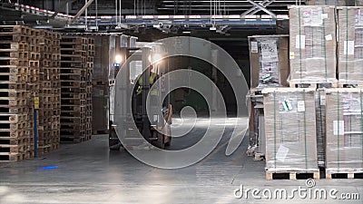 Fork lifter work in big warehouse. Clip. Warehouse man worker with forklift. Warehouse Rack of the Company Stock Photo