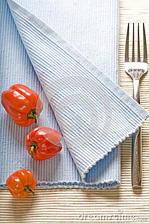 Fork and peppers on blue napkin Stock Photo