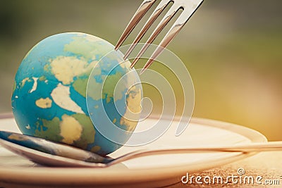 Fork slammed on Globe model placed on plate for serve menu in famous hotel. International cuisine is practiced around the world Stock Photo