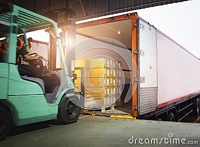 Forklift Driver Loading Package Boxes into Cargo Container. Cargo Trailer Truck Parked Loading at Dock Warehouse. Stock Photo