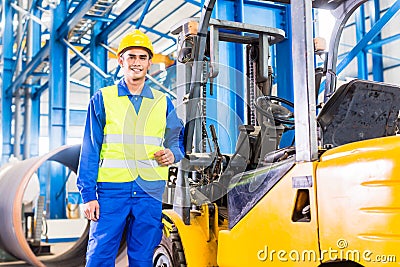 Forklift driver standing in manufacturing plant Stock Photo