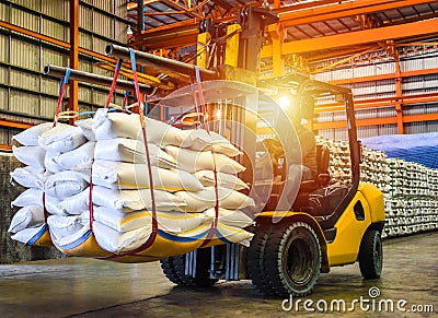 Forklift handling sugar bag for stuffing into container for export. Stock Photo