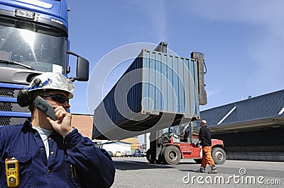 Forklift hoisting cargo and shipping containers Stock Photo