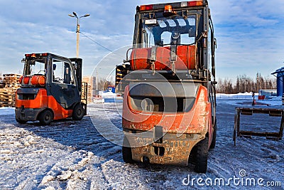 Forklift loaders for warehouse are waiting work outdoors during frosty day in the cargo center. Pallet stacker trucks in Stock Photo