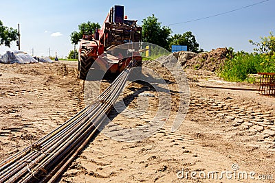 Forklift lifts the rebar bundle from ground on building site Stock Photo