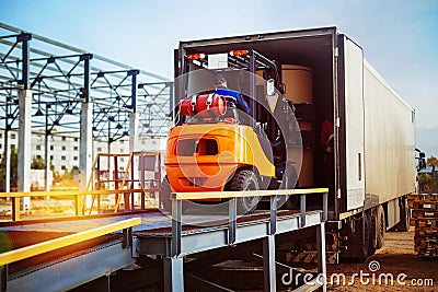 Forklift is putting cargo from warehouse to truck Editorial Stock Photo