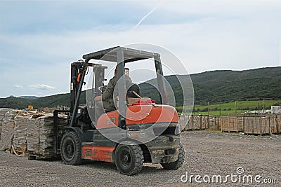 Forklift worker picking up pallet Editorial Stock Photo