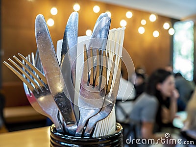 Forks, knives and dinning napkins placed in a cylindrical container Stock Photo