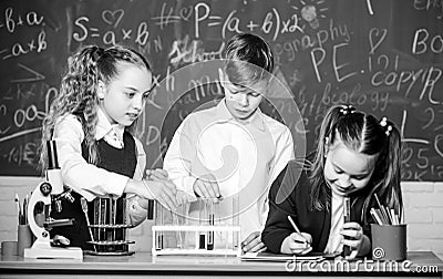 Formal education. Girls and boy student conduct school experiment with liquids. School laboratory. Group school pupils Stock Photo