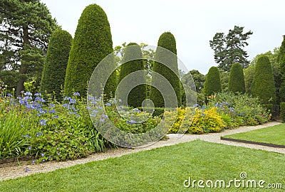 Formal english garden with conifer trees, flowerbeds Stock Photo