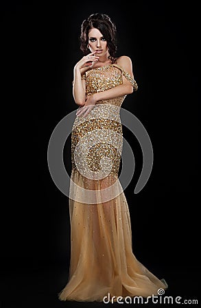Formal Party. Glamorous Fashion Model in Elegant Golden Dress over Black Stock Photo