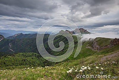 The formation and movements of clouds up to the steep slopes of the mountains of Central Caucasus peaks. Stock Photo