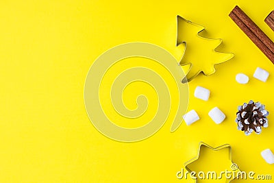 Forms for cookies, marshmallows and cinnamon on a yellow background copy space. The concept of Christmas and New Year. Stock Photo