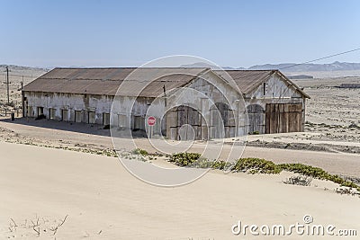forsaken warehouse buildings on sand at mining ghost town in desert, Kolmanskop, Namibia Stock Photo