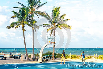 FORT LAUDERDALE, FLORIDA - September 20, 2019: men exercising in the public exercise equipment area and basketball Editorial Stock Photo