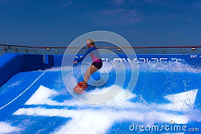 FORT LAUDERDALE, USA - APRIL 29, 2018: Man surfing on the FlowRider aboard the Oasis of the Seas by Royal Caribbean Editorial Stock Photo