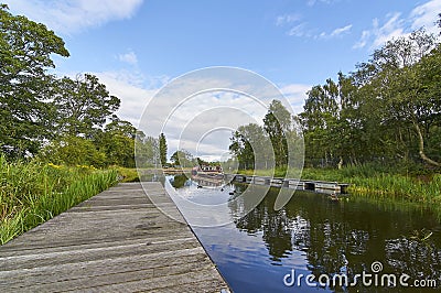 The Forth and Clyde canal, part of Scotlands waterways Heritage near the Falkirk Wheel with Narrow Boats moored along the Bank. Stock Photo