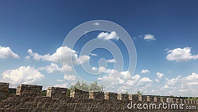 fortified castle wall on background blue sky with cloud Stock Photo