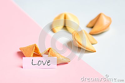 fortune cookie on pink and blue background, pastel colors, love prediction Stock Photo