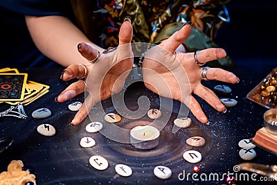 A fortune teller conjures a candle surrounded by runes and the magic aura. The concept of divination, astrology and predicting the Stock Photo