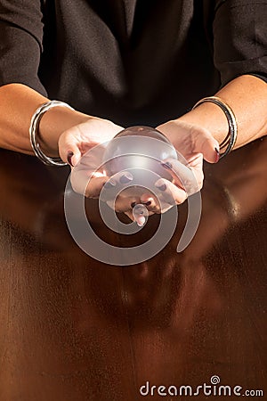 Fortune teller holding a glowing glass sphere Stock Photo