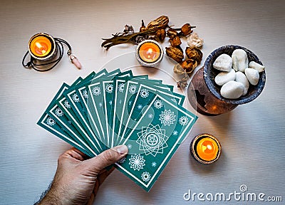 Fortune teller man with blue tarot cards on white wooden table b Stock Photo