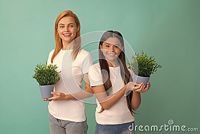 Fostering and adoption. Happy adopted child and mother hold houseplants. Foster family. Fostering Stock Photo