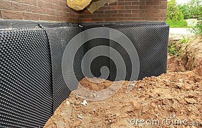 Foundation foam insulation with bitumen waterproofing, damp proofing on the house foundation wall Stock Photo