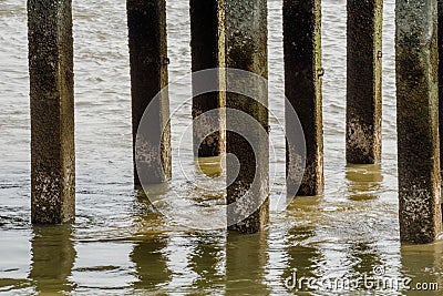 Foundation piles of pier make turbulence water flow or whirlpool in the river. Stock Photo